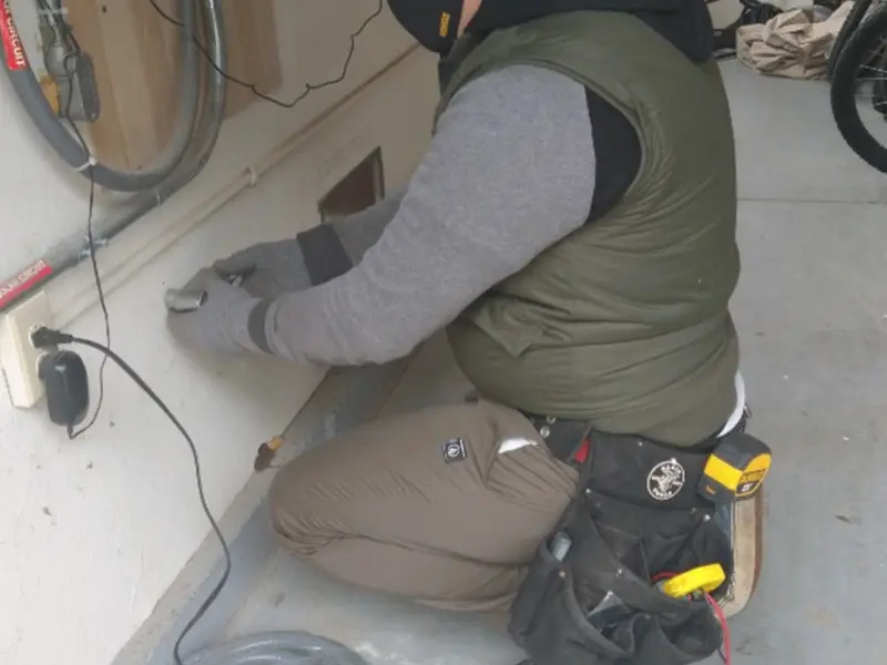 Electrician performing outlet wiring in a Maple Heights-Lake Desire garage